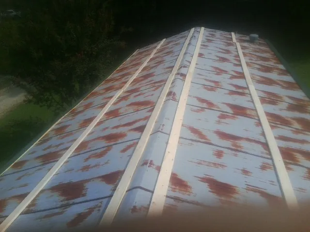 Rusted metal roof panels with new wood purlins before replacement — Storm Damage Roof Repair in Cantonment by Roofing Brothers