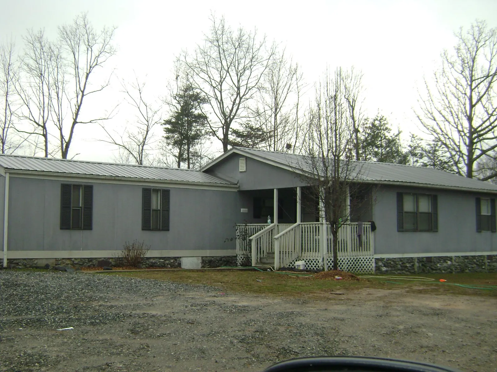 Metal roof over a manufactured home with a covered front porch in Cantonment