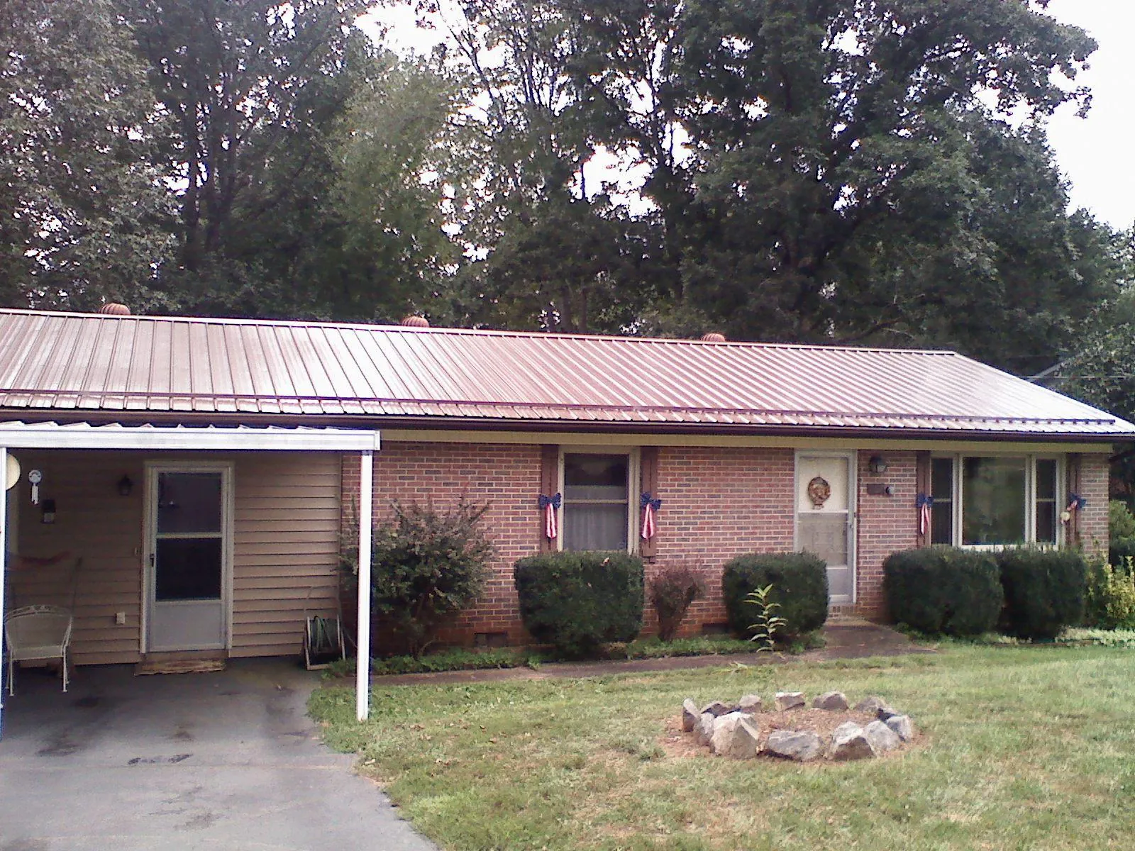 Bronze metal roof and carport on a brick ranch home — Roof Repair work by our crew in Cantonment
